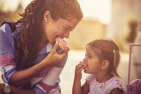 mother and daughter enjoying donuts on national donuts day